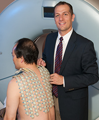 Electrophysiologist Phillip Cuculich, MD, adjusts an Electrocardiographic imaging (ECGI) vest on a patient.