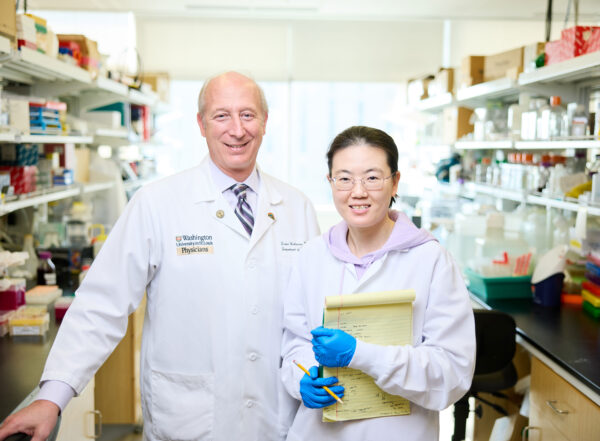 David Holtzman and Xiaoying Chen stand in a laboratory