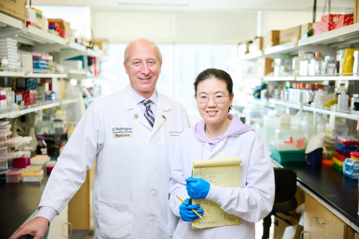 David Holtzman and Xiaoying Chen stand in a laboratory