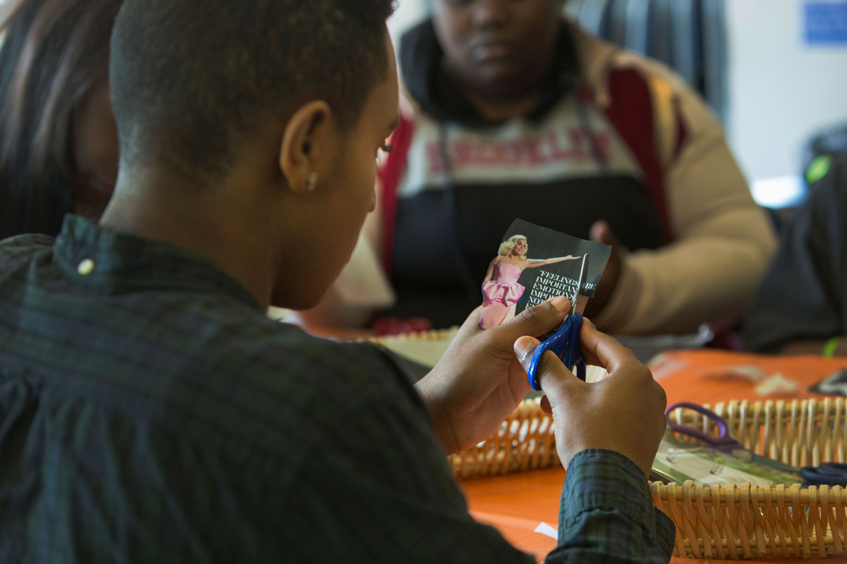 Noah Lowery, a client at The SPOT, creates a magnet with a picture of Lady Gaga, during a visit to the youth center by representative's of the pop star's Born This Way Foundation.