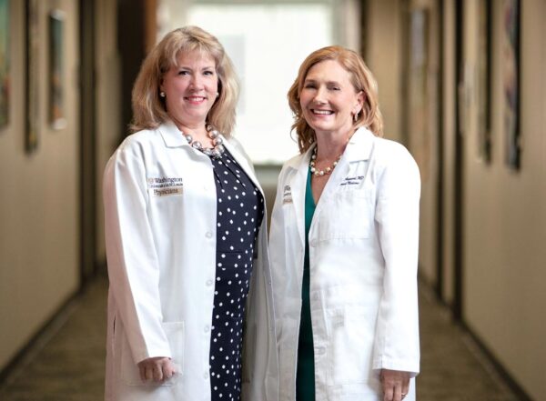 Valerie Ratts and Eva Aagaard wearing white coats and smiling into camera