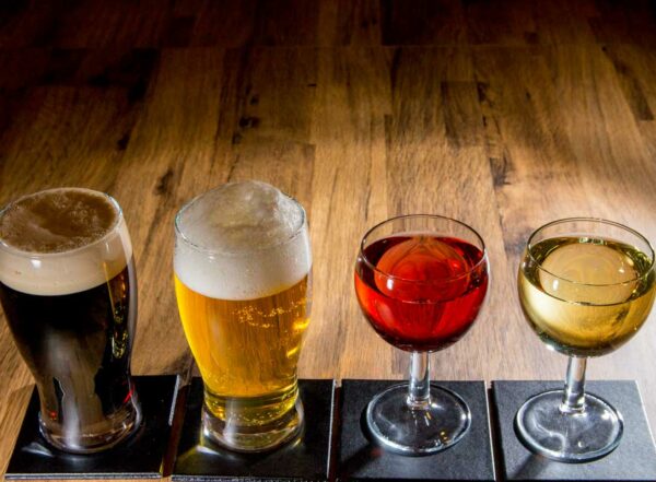 Photo showing two glasses of glasses of beer and two glasses of wine lined up on a table