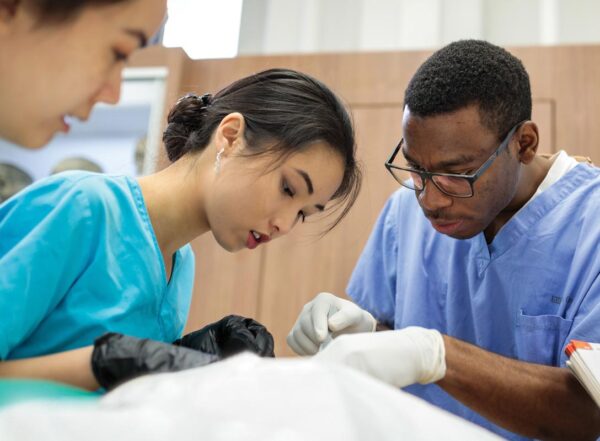 Sarah Chiang, Michelle Cai and Stanley Chibueze participate in their final day of dissection in anatomy class during their first year of medical school in 2018.