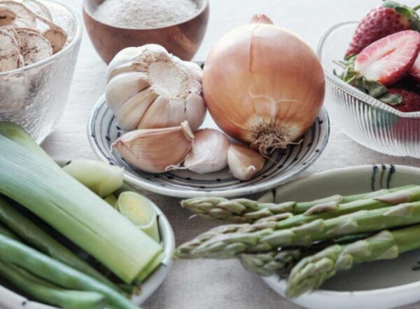 Plates of fresh vegetables including leeks, garlic and asparagus
