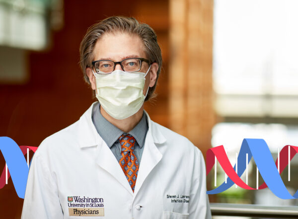 Dr. Steve Lawrence poses for a portrait wearing his white coat and a face mask