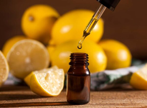 Lemon essential oil and lemon fruits on wooden background