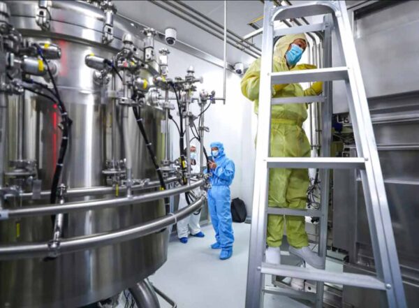 Staff members check and clean equipment at a vaccine production plant operated by SinoPharm in Beijing.