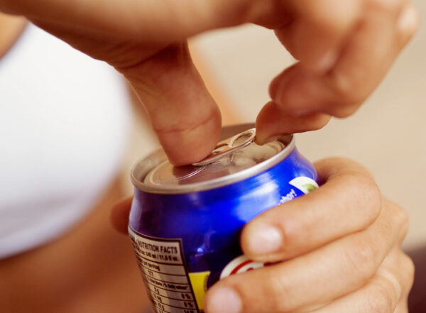 A person opens a can of a soft drink
